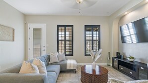 A living room with a grey sofa, a round coffee table, and a TV on the wall. - Unique and Secluded home, traffic-free and quite (El Paso)