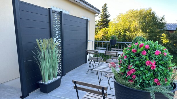 A patio with a black fence, a wooden bench, and a large planter with pink flowers. - The countryside, 5 minutes from downtown Tours (Fondettes)