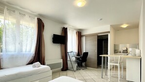 A hotel room with a bed, a desk, a chair, a TV, and a bathroom. - The countryside, 5 minutes from downtown Tours (Fondettes)
