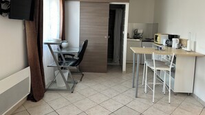 A modern kitchen with a microwave, coffee maker, and a small dining area with a table and chairs. - The countryside, 5 minutes from downtown Tours (Fondettes)