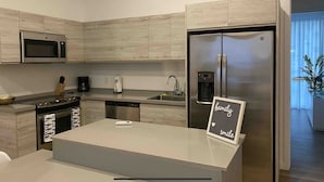 A modern kitchen with a stainless steel refrigerator, a microwave, and a dishwasher. - Villa Walking Distance to Eagle Beach (Noord)