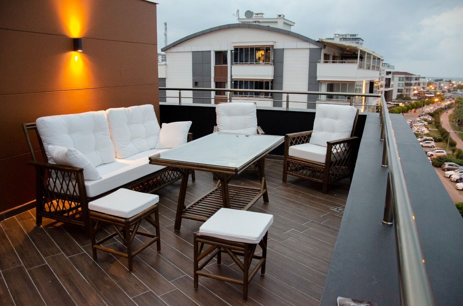 Una terraza en la azotea con un conjunto de sofás, una mesa y sillas.