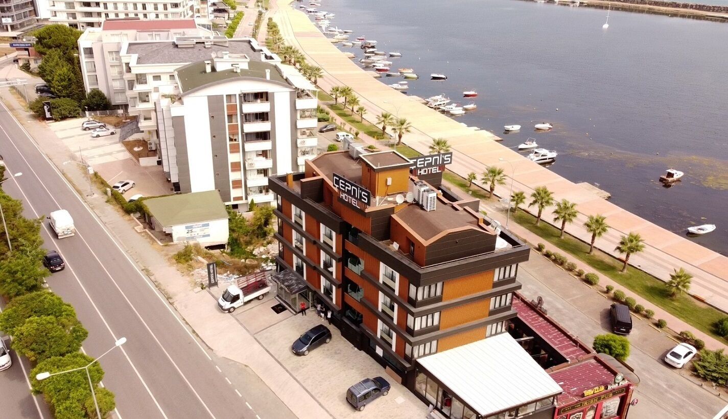 Un hotel dal design moderno situato vicino a una spiaggia con imbarcazioni.
