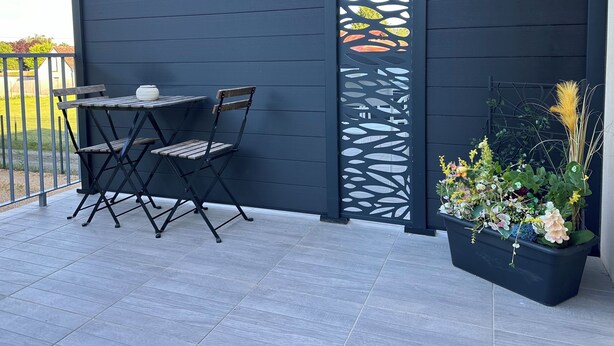 A patio with a dark blue fence, a table with two chairs, and a potted plant with flowers. - The countryside 5 minutes from Tours (Fondettes)