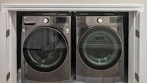 A compact laundry room with two front-loading washing machines. - 3BR Sunshine basement w separate entrance Waterloo (Waterloo)