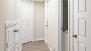 A hallway with white doors, a wooden floor, and recessed ceiling lights. - 3BR Sunshine basement w separate entrance Waterloo (Waterloo)
