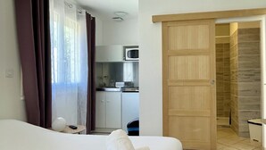 Ein Hotelzimmer mit Bett, Bad und einer Küchenzeile.