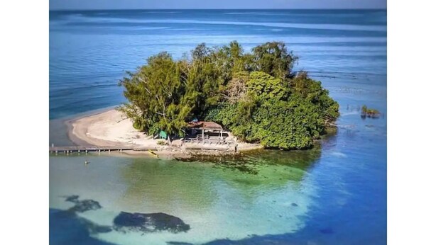 Isla apartada con una pequeña construcción y un muelle.