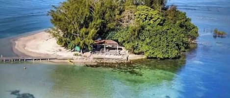 Isla apartada con una pequeña construcción y un muelle.