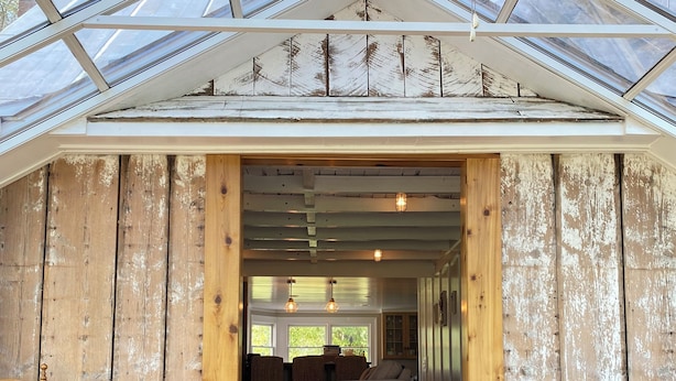 Une pièce chaleureuse avec un décor intérieur en bois, un plafond en verre et une vue sur l’extérieur.