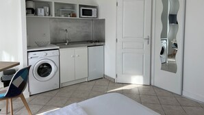 A compact kitchen with a washing machine, microwave, and sink. - The charm of Touraine (Fondettes)