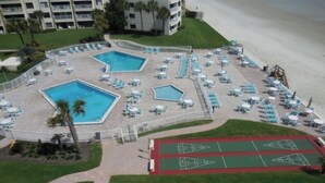 An aerial view of a hotel with multiple swimming pools, sun loungers, and shuffleboard courts. - ERROL BY THE SEA, 2bdrm 2 bath FIRST FLOOR (New Smyrna Beach)