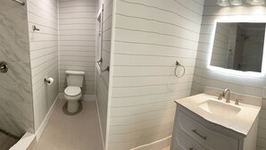 Une salle de bain équipée de toilettes, d’une douche et d’un lavabo.