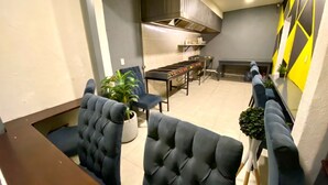 Un interior moderno con comedor, cocina y zona de estar, con una planta en maceta.