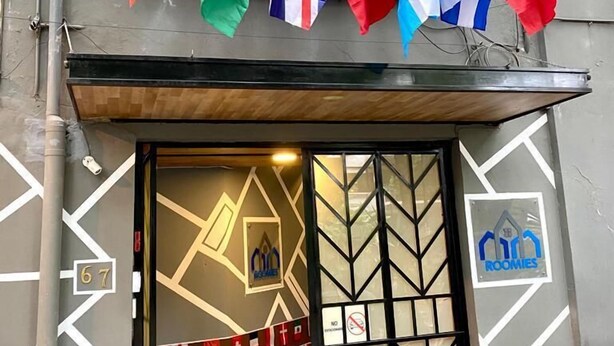 A building entrance with multiple national flags displayed above the door. - RHM Hostel  (Mexico City)