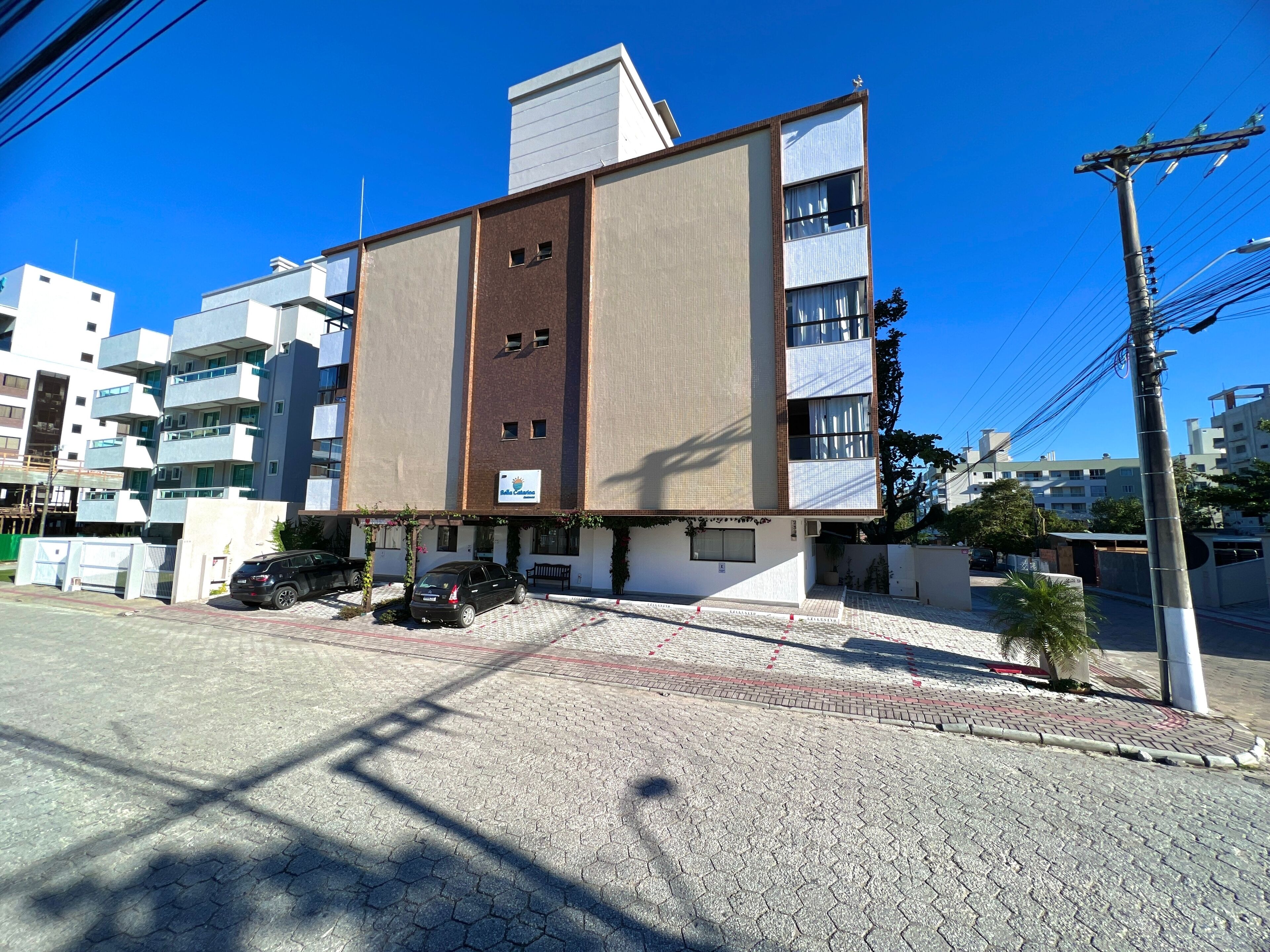 Un edificio moderno con techo plano, varios balcones y un cartel que indica que es un hotel.