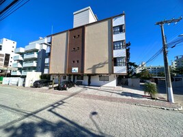 Un edificio moderno con techo plano, varios balcones y un cartel que indica que es un hotel.