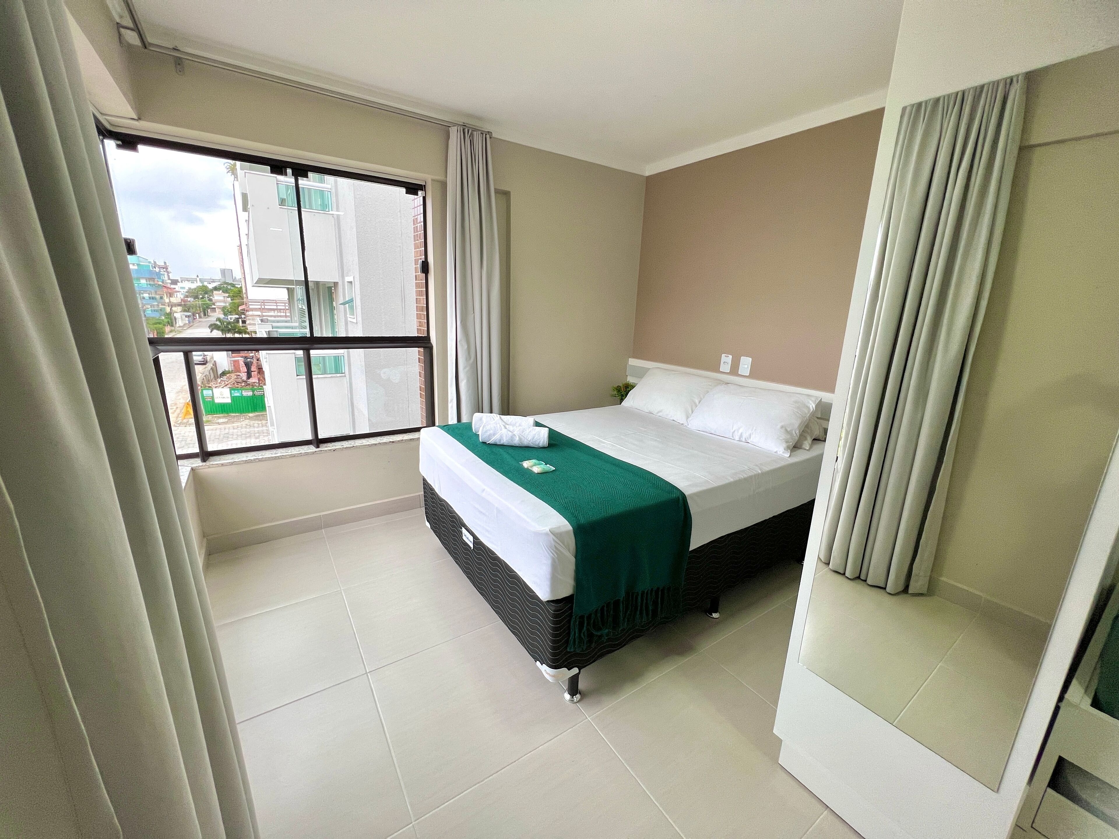 Una habitación de hotel con cama, ventana y vistas al exterior.