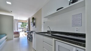 A modern kitchen with a built-in microwave, a sink, and a countertop. - Bella Catarina Bombinhas (Bombinhas)
