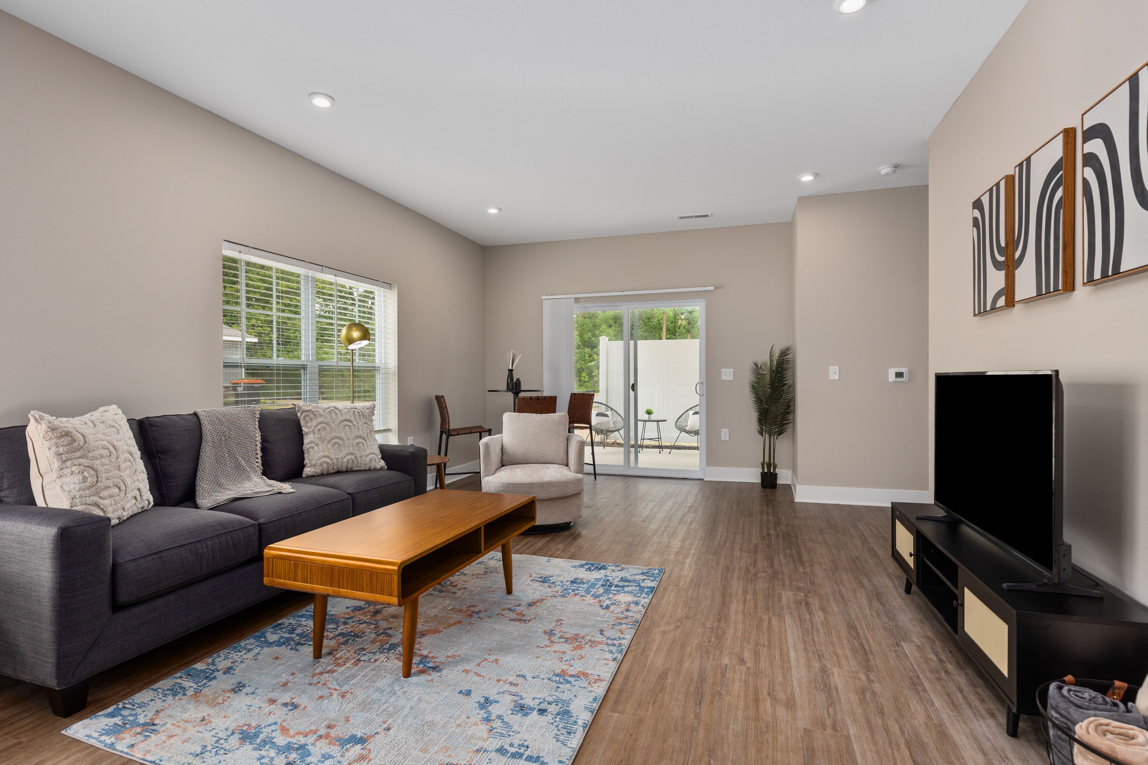 A modern living room with a sofa, coffee table, and TV stand.