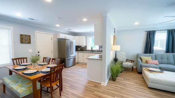 Un appartement moderne comprenant un coin repas, une cuisine et un salon.