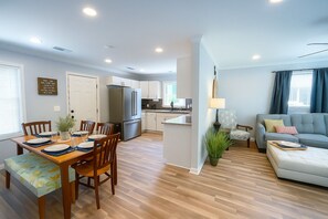 Um apartamento moderno com sala de jantar, cozinha e sala de estar.