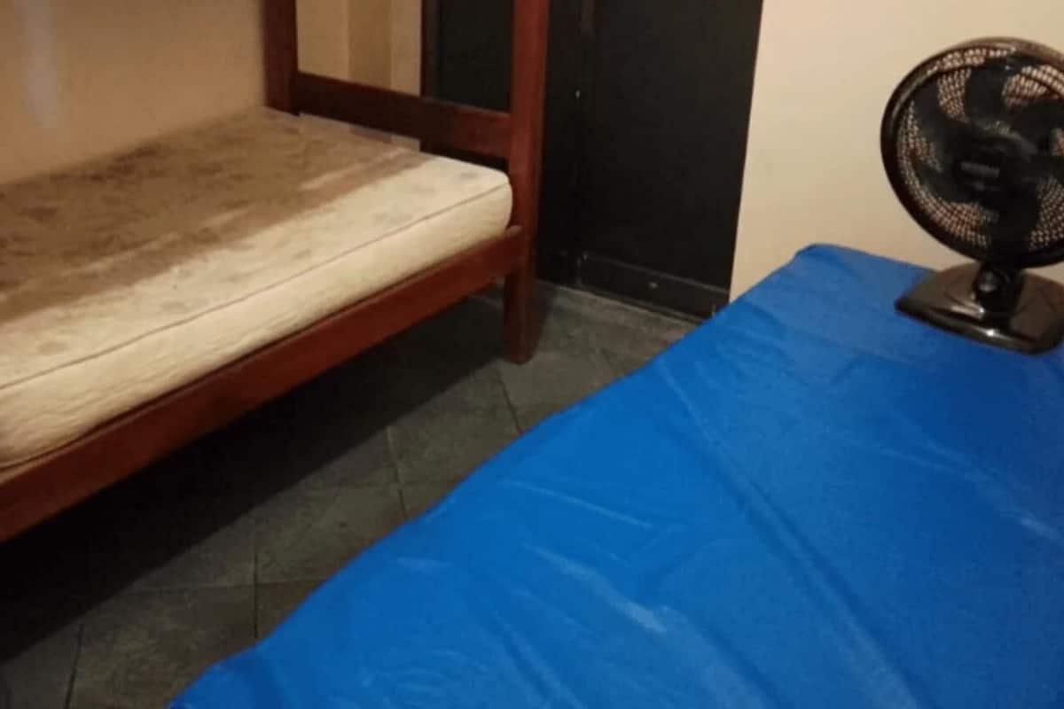 A bunk bed with a mattress and a blue tablecloth.