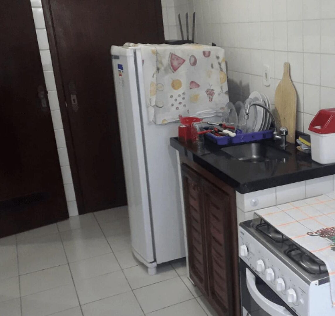 Una cocina con refrigerador, estufa, lavabo y armarios de madera.