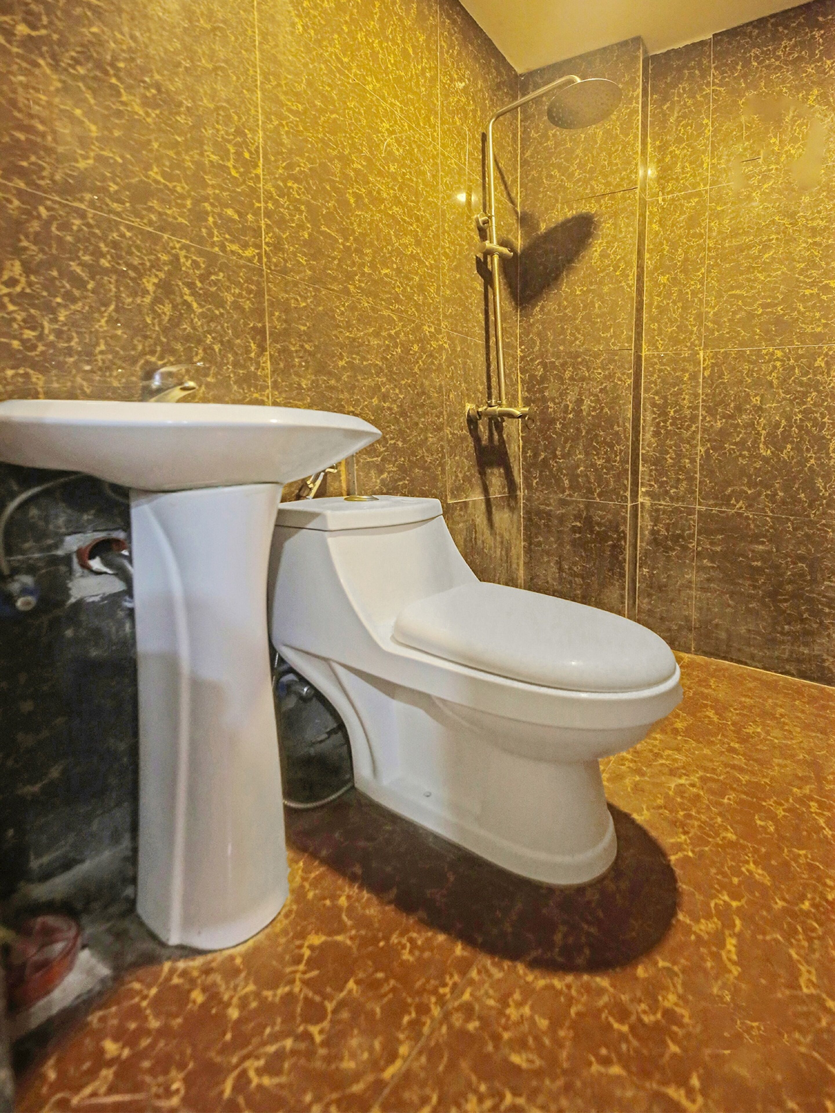 A bathroom with a toilet, sink, and shower.