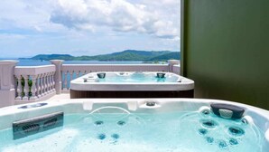A hot tub on a balcony with a view of the sea and mountains. - 360 Splendor 406-Condo with Breakfast Included (360 Splendor)