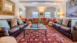 A spacious living room with leather sofas, a glass coffee table, and a patterned rug. - July 4 special: Sleep 20, 6BR/6BA. Pool, tennis, views, resort. Dogs loved! (Manchester)