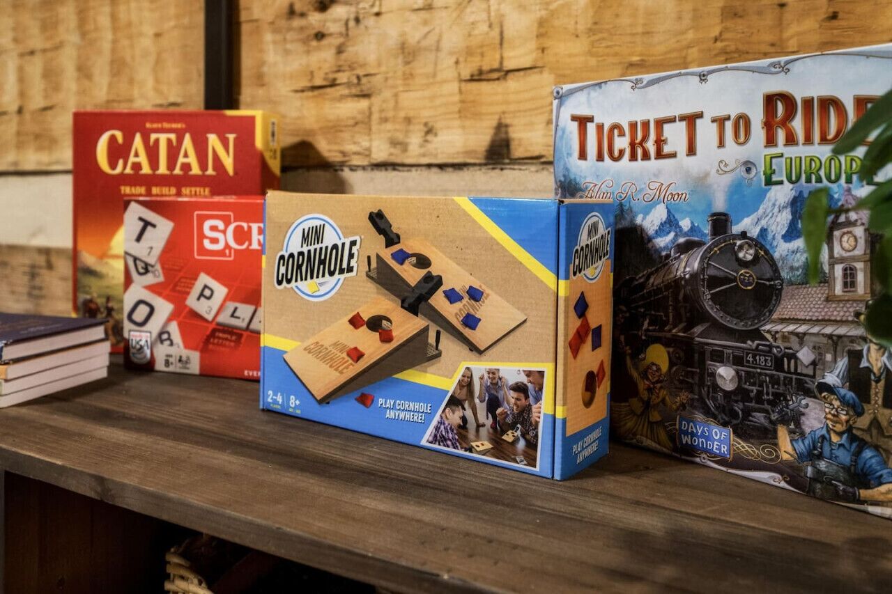 Three board games: Catan, Mini Cornhole, and Ticket to Ride Europe.