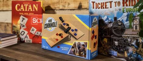 Three board games: Catan, Mini Cornhole, and Ticket to Ride Europe.