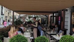 An outdoor café with tables and chairs, surrounded by potted plants. - Best Western Plus Market Square Lviv (Lviv)