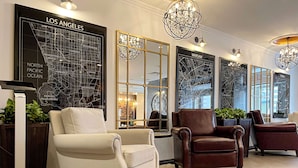 A modern hotel lobby with a large map of Los Angeles, a chandelier, leather armchairs, and a large mirror. - Best Western Plus Market Square Lviv (Lviv)