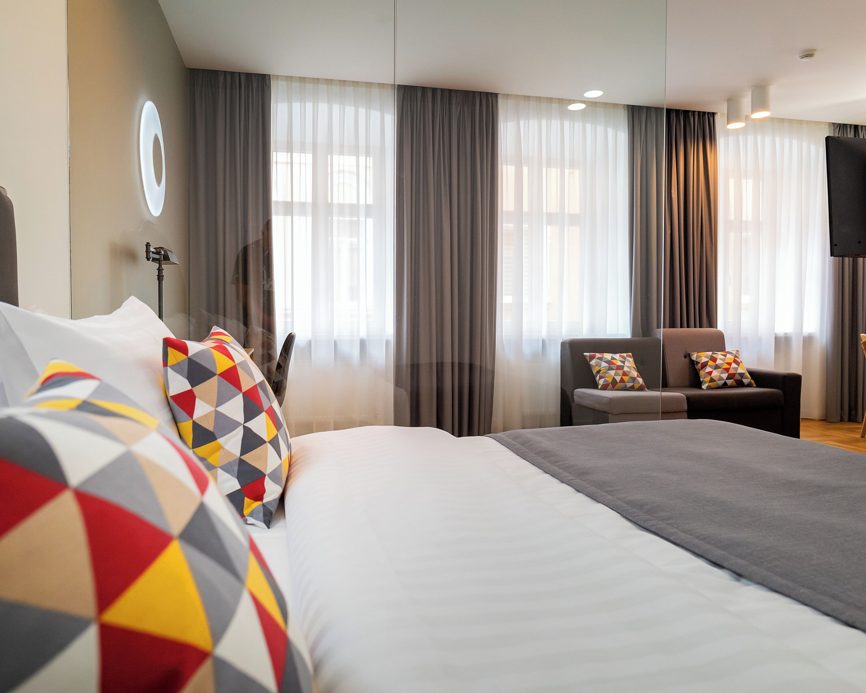 Une chambre d’hôtel avec un grand lit, une chaise et un téléviseur.