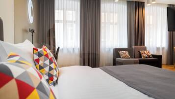 Une chambre d’hôtel avec un grand lit, une chaise et un téléviseur.