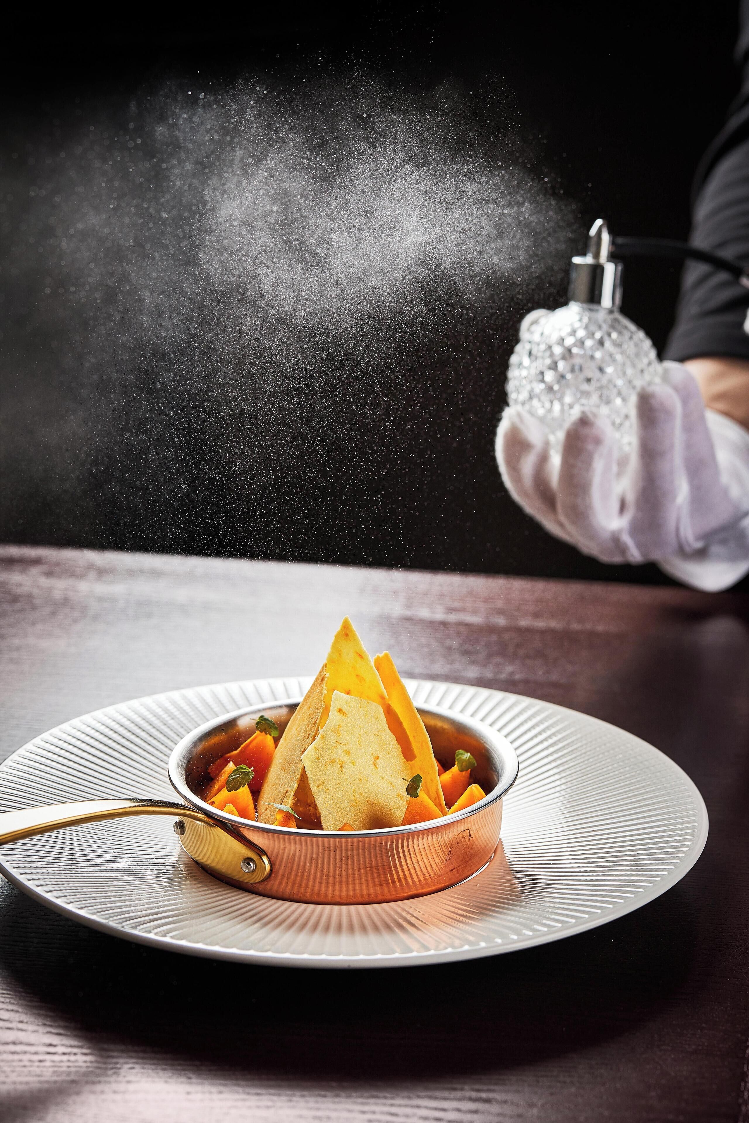 A dish with a golden-brown crust, possibly a pie or tart, on a white plate with a gold handle.