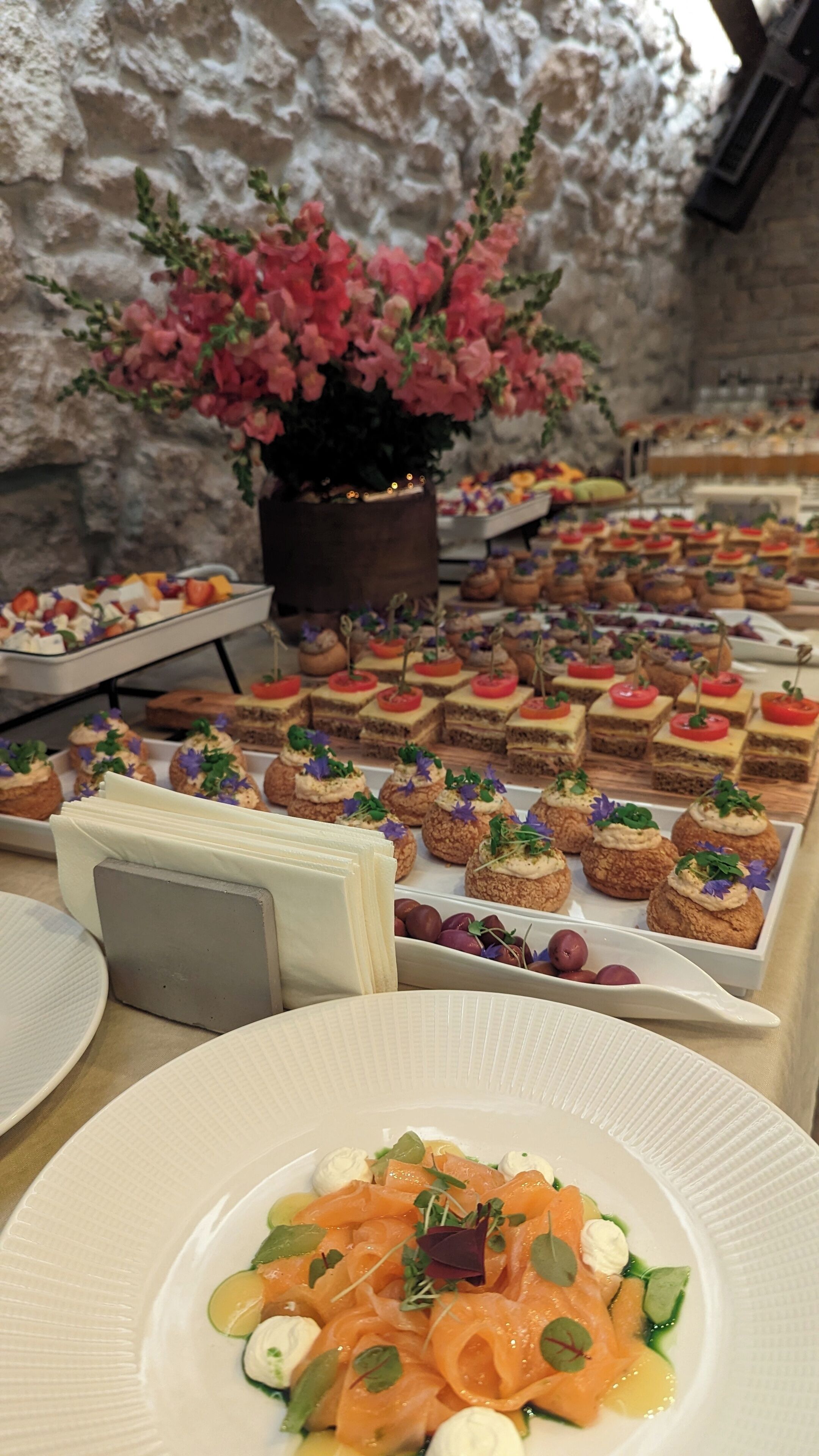 Un buffet proposant une variété de plats, notamment des pâtisseries et une assiette de salade de saumon.