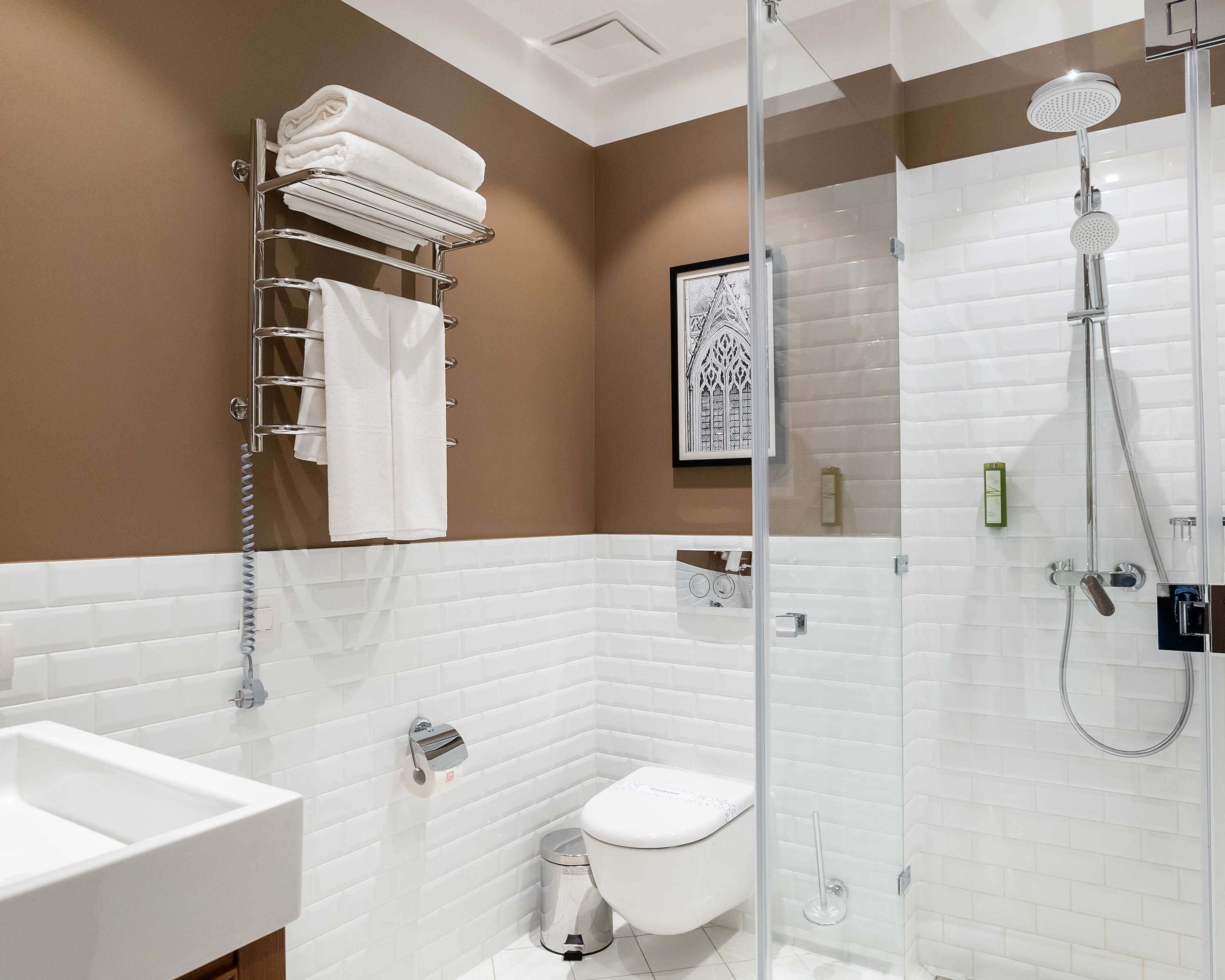 Un baño moderno con ducha de vidrio, inodoro y lavamanos.