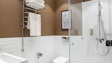 Un baño moderno con ducha de vidrio, inodoro y lavamanos.
