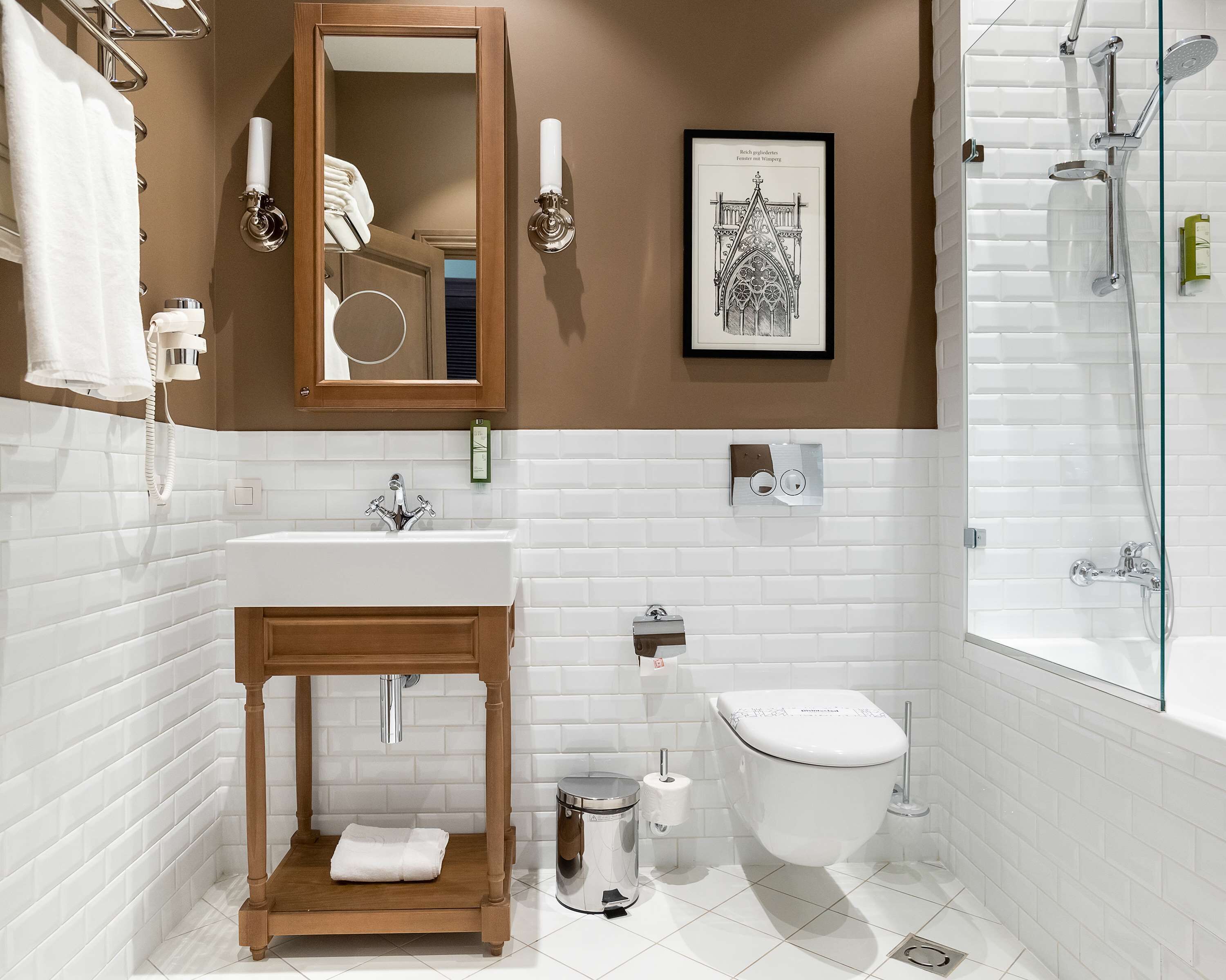 Une salle de bain moderne avec un meuble-lavabo en bois, un lavabo blanc et une cabine de douche en verre.