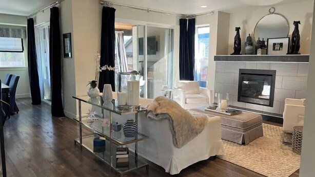 A modern living room with a glass coffee table, a white sofa, and a fireplace. - Modern home in downtown Sumner, WA, 34 mi from Lumen Field (Sumner)