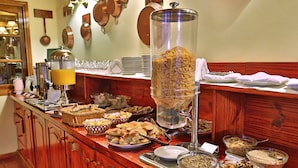 A buffet setup with various food items and a coffee station. - Hotel Sirenuse (Mar del Plata)