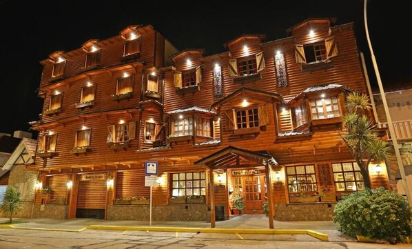 A multi-story wooden building with balconies and a covered entrance.