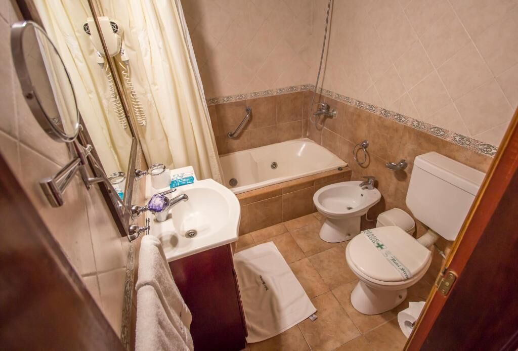 A bathroom with a bathtub, bidet, toilet, and sink.