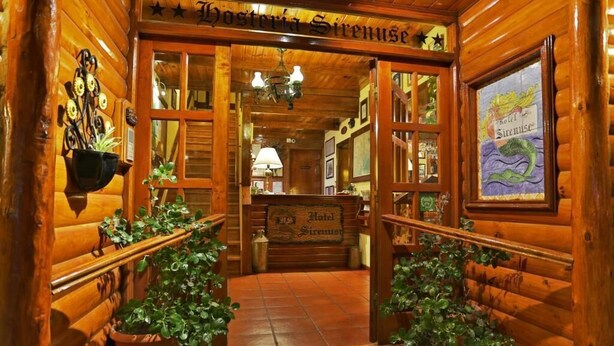 A wooden log cabin interior with a sign reading "Hotel Sirenuse." - Hotel Sirenuse (Mar del Plata)