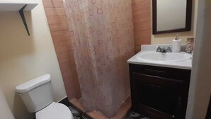 A small bathroom with a toilet, a sink, and a shower curtain.