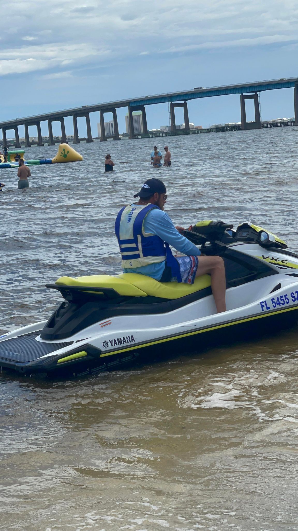 Eine Person fährt auf einem Yamaha Jet-Ski auf dem Wasser, im Hintergrund eine Brücke.