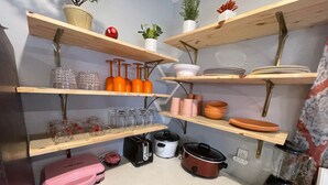 A kitchen with wooden shelves holding various kitchenware, a toaster, a slow cooker, and a blender. - New! GREEN HOUSE minutes from Navarre beach and restaurants (Navarre)